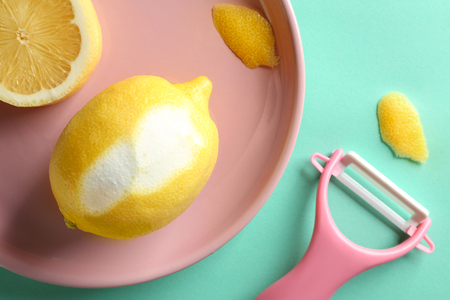 Pink plate with lemon and zester on color backgroundの写真素材