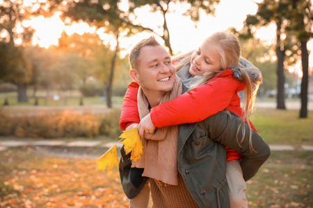 Happy father and his little daughter in autumn parkの写真素材