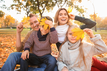 Portrait of happy family in autumn parkの写真素材