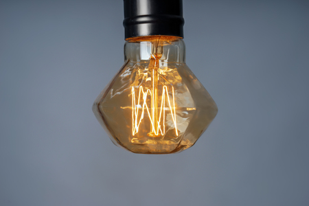 Retro light bulb on grey backgroundの写真素材