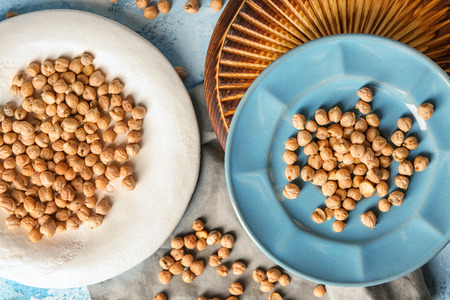 Plates with dry chickpeas on tableの写真素材