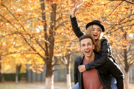 Happy young couple having fun in autumn parkの写真素材