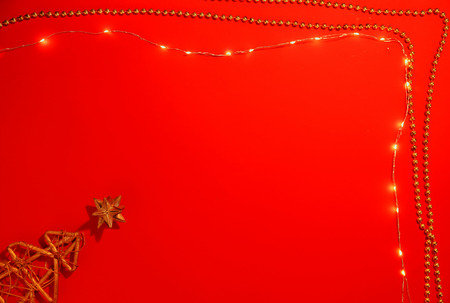 Christmas lights on red background, top view