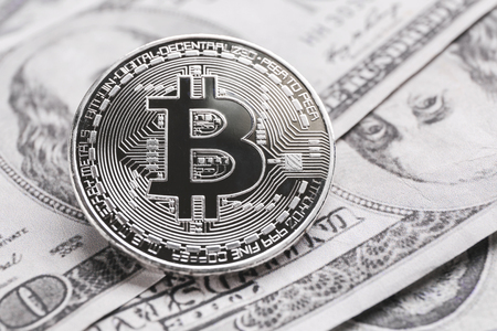 Silver bitcoin on dollar banknotesの写真素材
