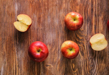 Cut and whole juicy apples on wooden tableの写真素材