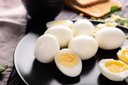 Plate with tasty boiled eggs on dark table, closeupの写真素材
