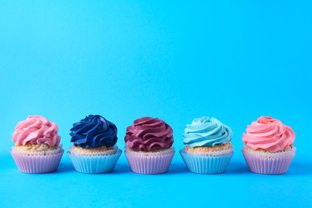 Tasty cupcakes on color background