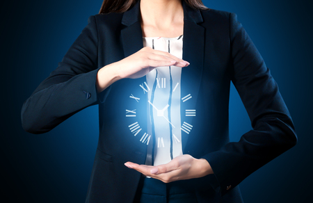 Businesswoman with virtual clock on dark background. Time management conceptの写真素材