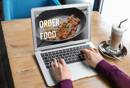 Woman using laptop to order food delivery onlineの写真素材