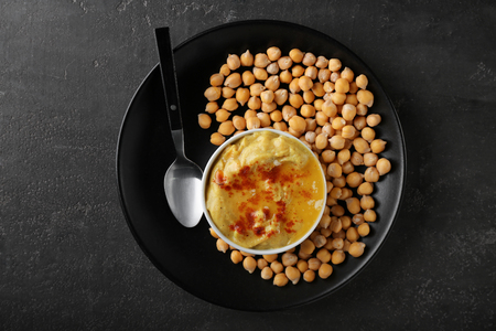 Bowl with tasty hummus and chickpeas on plateの写真素材
