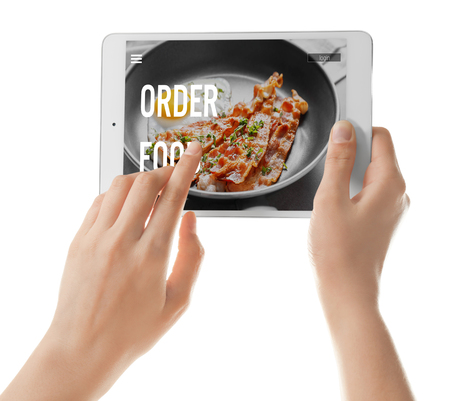 Woman using tablet computer to order food delivery online on white backgroundの写真素材