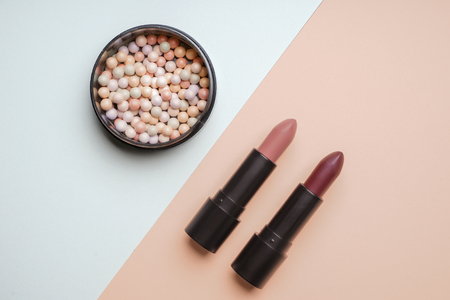 Lipsticks with face powder on color backgroundの写真素材
