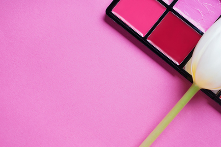 Palette of different lipsticks with flower on color backgroundの写真素材