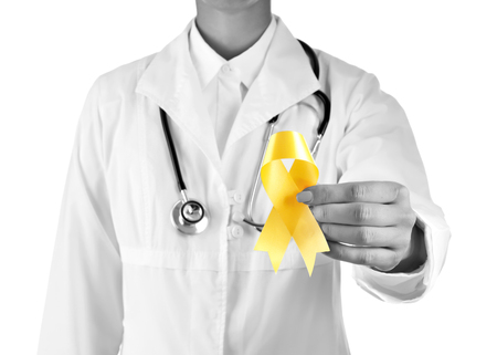 Doctor with yellow ribbon on white background. Cancer awareness conceptの写真素材
