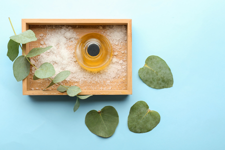 Box with bottle of eucalyptus essential oil and sea salt on color backgroundの写真素材