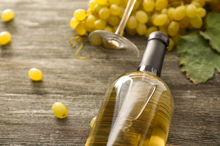 Bottle of wine and grapes on wooden tableの写真素材