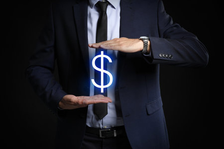 Male bank manager with dollar sign on dark backgroundの写真素材