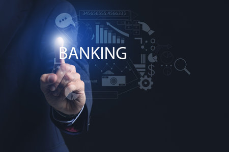 Male bank manager using virtual screen on dark backgroundの写真素材