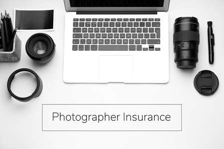 Modern professional equipment and laptop with text PHOTOGRAPHER INSURANCE on white backgroundの写真素材