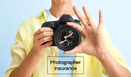 Young female photographer with damaged photo camera on color background. Concept of insuranceの写真素材