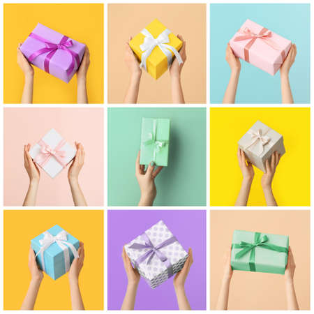 Female hands with beautiful gift boxes on colorful backgroundの写真素材