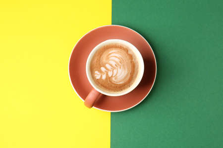 Cup of tasty cappuccino on color backgroundの写真素材