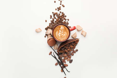Composition with cup of tasty cappuccino and roasted beans on white background