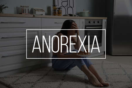 Young woman suffering from anorexia in kitchenの写真素材