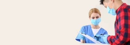 Female receptionist with patient in clinicの写真素材