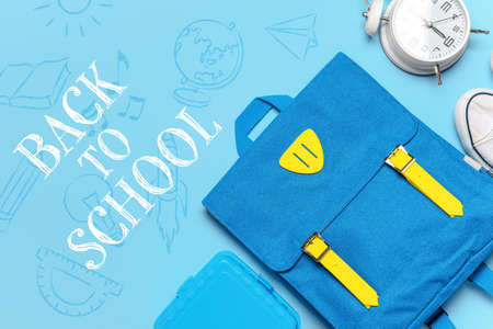 Backpack with stationery and phrase BACK TO SCHOOL on color background