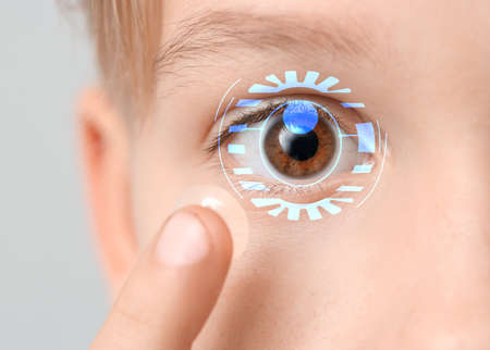 Little boy putting in contact lens, closeup