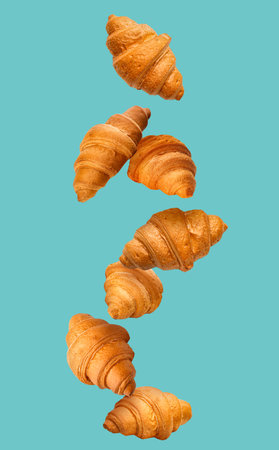 Falling croissants on color background