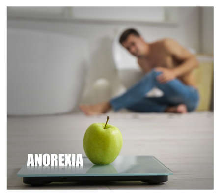 Scales with apple on floor in bathroom. Concept of anorexiaの写真素材