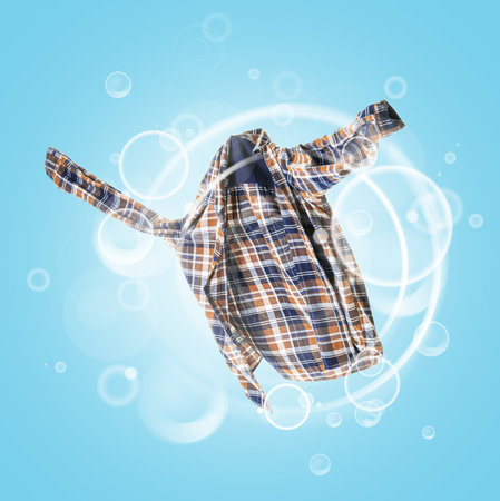 Clean shirt with soap bubbles on color backgroundの写真素材