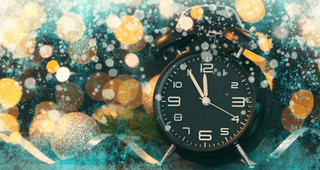 Alarm clock and Christmas decor against dark background with blurred lightsの写真素材