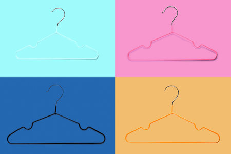 Set of clothes hangers on color background
