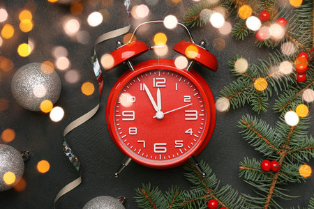 Alarm clock, Christmas decor and fir branches on dark background