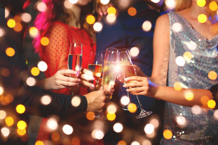 Young people clinking glasses of tasty champagne at partyの写真素材