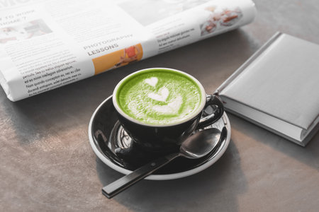 Tasty matcha tea in cup on table