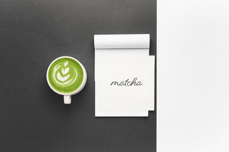 Cup of matcha tea with notebook on dark backgroundの写真素材