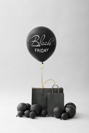 Shopping bags and balloons on gray background. Black Friday saleの写真素材