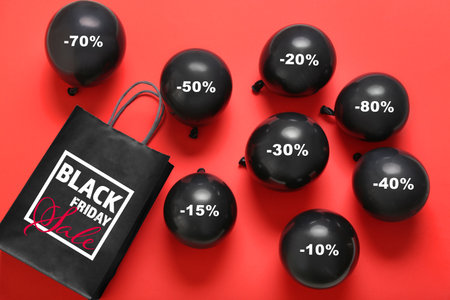 Balloons and shopping bag with text BLACK FRIDAY SALE on color backgroundの写真素材