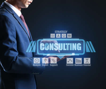 Business consultant with tablet computer using virtual screen on dark backgroundの写真素材