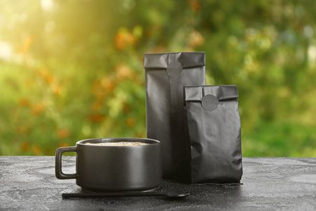 Paper bags for coffee and cup of hot drink on table outdoorsの写真素材
