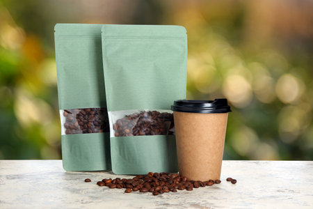 Paper bags and cup for coffee on table outdoors