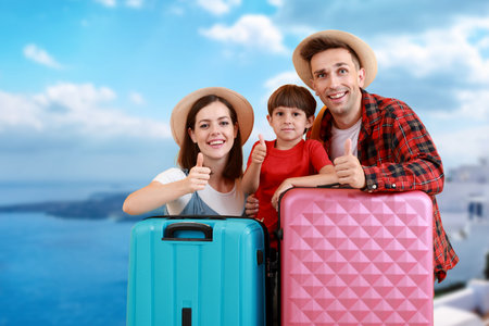 Happy family with luggage at sea resortの写真素材