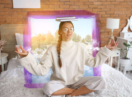 Beautiful young woman with books meditating in bedroom. Zen concept