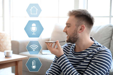 Man with mobile phone in room. Modern technology and smart home automationの写真素材