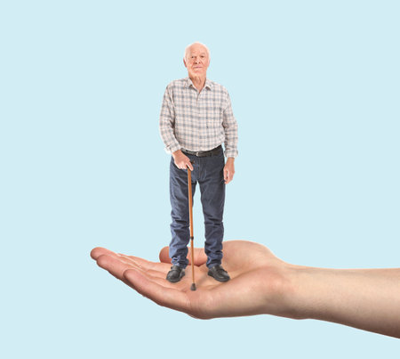 Male hand holding senior man on color backgroundの写真素材