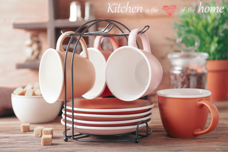 Holder with cups and saucers on kitchen tableの写真素材
